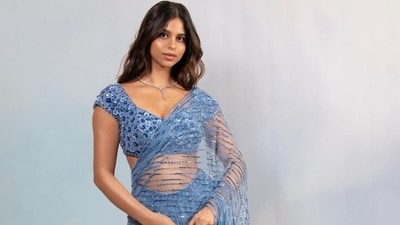 Suhana Khan seems to have a thing for sarees, especially the glamorous kinds. In March 2024, she posted this photo of herself decked out in a custom Falguni Shane Peacock Parisian blue, pre-draped saree. It was adorned with Swarovski stones, blue sequins, beads, and acrylic flowers and paired with a cap-sleeved blouse. Suhana styled the look with minimal statement jewellery and a wavy hairdo. Suhana Khan seems to have a thing for sarees, especially the glamorous kinds. In March 2024, she posted this photo of herself decked out in a custom Falguni Shane Peacock Parisian blue, pre-draped saree. It was adorned with Swarovski stones, blue sequins, beads, and acrylic flowers and paired with a cap-sleeved blouse. Suhana styled the look with minimal statement jewellery and a wavy hairdo.
