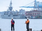 Two staff members look on as navy ships park at the port, as China announces new military drills around Taiwan, in Keelung, Taiwan May 23, 2024. 