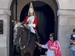 A tourist gets bitten by a King's Guard horse in the UK while posing for a photo. A tourist gets bitten by a King's Guard horse in the UK while posing for a photo.
