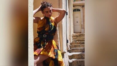 Her sleeveless ensemble comes in shades of yellow, black and green and features a halter neckline, a black satin belt to cinch in the waist and a gathered design at the front and back of the bodice. The ruffled tier at the high-low hem of the dress shows off her legs and cascades down the back to form a floor-sweeping train for added drama. (Instagram/@aditiraohydari)