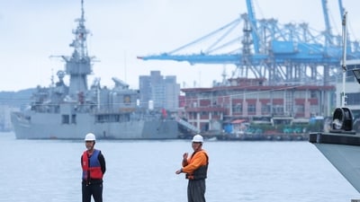 Two staff members look on as navy ships park at the port, as China announces new military drills around Taiwan, in Keelung, Taiwan May 23, 2024. (REUTERS)