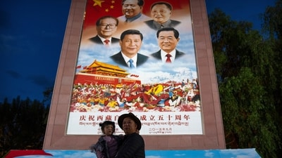 Chat Xi PT: A man holds a girl as they pose for a photo in front of a large mural depicting Chinese President Xi Jinping, bottom center, and other Chinese leaders at a public square at the base of the Potala Palace. (AP) Chat Xi PT: A man holds a girl as they pose for a photo in front of a large mural depicting Chinese President Xi Jinping, bottom center, and other Chinese leaders at a public square at the base of the Potala Palace. (AP)