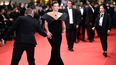 US actress Bella Thorne arrived at Cannes for the screening of the film "Motel Destino" wearing a structured strapless dress in a muted dark tone. The dress featured a reflective corset top and draped fabric on the skirt. The skirt featured a high slit and gathered fabric around the dropped waist, while the corset top created the illusion of gathered, layered fabric, reflecting the lights of flashing cameras and adding a captivating element to her ensemble. (Photo by LOIC VENANCE / AFP) US actress Bella Thorne arrived at Cannes for the screening of the film "Motel Destino" wearing a structured strapless dress in a muted dark tone. The dress featured a reflective corset top and draped fabric on the skirt. The skirt featured a high slit and gathered fabric around the dropped waist, while the corset top created the illusion of gathered, layered fabric, reflecting the lights of flashing cameras and adding a captivating element to her ensemble. (Photo by LOIC VENANCE / AFP)