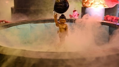 A Buddhist devotee pour holy water over Prince Siddhartha Gautama statue at a shopping mall in Surabaya, Indonesia. (AFP)