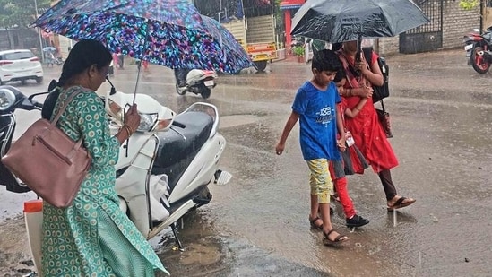 People seen walking with umbrellas amid heavy rainfall. People seen walking with umbrellas amid heavy rainfall.