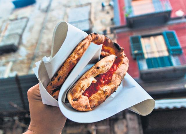 Italians eat pizzas with their fingers, sometimes with each slice folded up to four times. (SHUTTERSTOCK) Italians eat pizzas with their fingers, sometimes with each slice folded up to four times. (SHUTTERSTOCK)