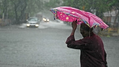 A pedestrian wades through a flooded street after heavy rain. (AFP) A pedestrian wades through a flooded street after heavy rain. (AFP)
