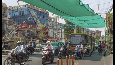 Vehicles at a traffic signal under a newly-installed green shade amid heatwave conditions, in Agra, on Friday (PTI Photo) Vehicles at a traffic signal under a newly-installed green shade amid heatwave conditions, in Agra, on Friday (PTI Photo)