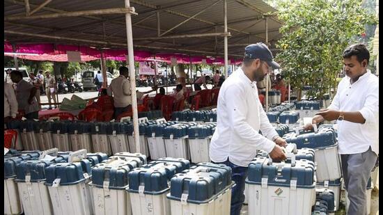 Polling officials with EVMs and other election material in Prayagraj on Friday. (PTI PHOTO)