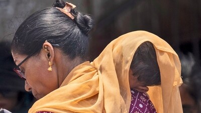 A woman covers her child with a scarf to save him from heat wave on a hot summer day in Mumbai, India, Thursday, May 23, 2024. (AP Photo/Rafiq Maqbool) (AP) A woman covers her child with a scarf to save him from heat wave on a hot summer day in Mumbai, India, Thursday, May 23, 2024. (AP Photo/Rafiq Maqbool) (AP)
