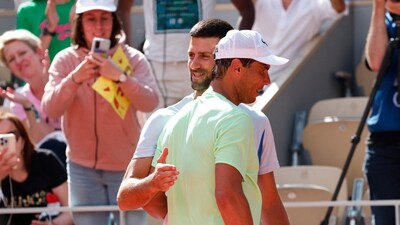 Serbia's Novak Djokovic hugs Spain's Rafael Nadal during a practice session. (REUTERS)