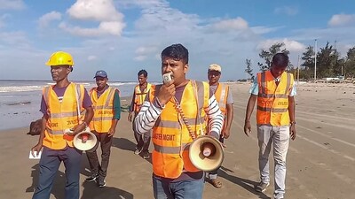 Personnel from West Bengal Disaster Management make announcements on the beach as part of precautionary measures ahead of the landfall of cyclone Remal in South 24 Parganas district on Friday. (PTI) (HT_PRINT) Personnel from West Bengal Disaster Management make announcements on the beach as part of precautionary measures ahead of the landfall of cyclone Remal in South 24 Parganas district on Friday. (PTI) (HT_PRINT)