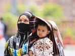 A woman covers her child in protection from the scorching sun on a hot summer day, in Jaipur. A woman covers her child in protection from the scorching sun on a hot summer day, in Jaipur.