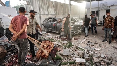 Palestinians inspect the aftermath of an Israeli strike on a building in Nuseirat (AFP)