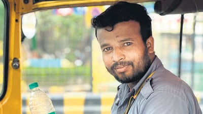 Shiv Kumar halts his autorickshaw to drink water. (HT Photo) Shiv Kumar halts his autorickshaw to drink water. (HT Photo)