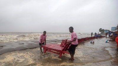 Cyclone Remal news: Men salvage a reclining chair and other material as water flows on to the Kuakata beach on the coast of Bay of Bengal caused by the advancing Cyclone Remal in Barisal, Bangladesh, on May 26, 2024. (AP) Cyclone Remal news: Men salvage a reclining chair and other material as water flows on to the Kuakata beach on the coast of Bay of Bengal caused by the advancing Cyclone Remal in Barisal, Bangladesh, on May 26, 2024. (AP)