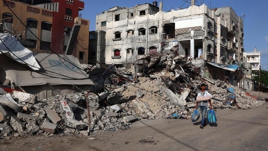 A Palestinian man walks past a destroyed building in Rafah in the southern Gaza Strip on May 26, 2024, amid the ongoing conflict between Israel and the Hamas militant group continues. (Photo by Eyad BABA / AFP)