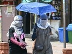 Women cover themselves with scarves and an umbrella to get shield from the sun during a hot summer day in New Delhi Women cover themselves with scarves and an umbrella to get shield from the sun during a hot summer day in New Delhi