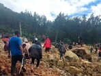 In this photo provides the International Organization for Migration, people cross over the landslide area to get to the other side in Yambali village, Papua New Guinea, Friday, May 24, 2024. In this photo provides the International Organization for Migration, people cross over the landslide area to get to the other side in Yambali village, Papua New Guinea, Friday, May 24, 2024.