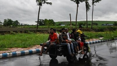 Commuters travel on a motorised three-wheeler along a road as rain clouds loom over the sky, due to the effect of cyclone Remal, in Kolkata. (AFP) Commuters travel on a motorised three-wheeler along a road as rain clouds loom over the sky, due to the effect of cyclone Remal, in Kolkata. (AFP)