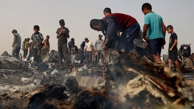Palestinians gather at the site of an Israeli strike on a camp for internally displaced people in Rafah. (AFP) Palestinians gather at the site of an Israeli strike on a camp for internally displaced people in Rafah. (AFP)