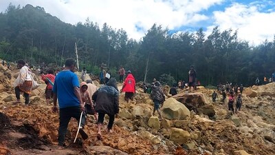In this photo provides the International Organization for Migration, people cross over the landslide area to get to the other side in Yambali village, Papua New Guinea, Friday, May 24, 2024. (AP) In this photo provides the International Organization for Migration, people cross over the landslide area to get to the other side in Yambali village, Papua New Guinea, Friday, May 24, 2024. (AP)