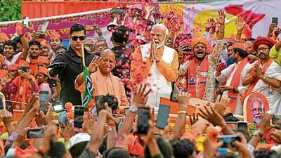 Prime Minister Narendra Modi and chief minister Yogi Adityanath during a road show in Varanasi on May 13. (AFP File Photo)