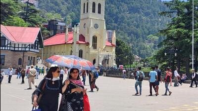 Residents using an umbrella to shield themselves from the heat on The Ridge, Shimla. (Deepak Sansta/HT)