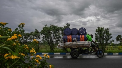Workers drive their motorised three-wheeler along a road as rain clouds loom over the sky due to the effect of Cyclone Remal in Kolkata on May 26, 2024. Efforts to restore normalcy are underway, with emergency services working to clear debris and restore power in the affected areas. (AFP) Workers drive their motorised three-wheeler along a road as rain clouds loom over the sky due to the effect of Cyclone Remal in Kolkata on May 26, 2024. Efforts to restore normalcy are underway, with emergency services working to clear debris and restore power in the affected areas. (AFP)