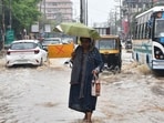A woman holding an umbrella passes through a waterlogged road after heavy rainfall following cyclone Remal, in Guwahati. A woman holding an umbrella passes through a waterlogged road after heavy rainfall following cyclone Remal, in Guwahati.