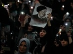 A woman holds up a poster of the late Iranian President Ebrahim Raisi at the mam Khomeini Grand Mosque in Tehran in a funeral ceremony for him and his companions who were killed in a helicopter crash on Sunday in a mountainous region of the country's northwest.&nbsp;