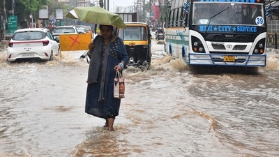 A woman holding an umbrella passes through a waterlogged road after heavy rainfall following cyclone Remal, in Guwahati. (ANI)