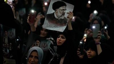 A woman holds up a poster of the late Iranian President Ebrahim Raisi at the mam Khomeini Grand Mosque in Tehran in a funeral ceremony for him and his companions who were killed in a helicopter crash on Sunday in a mountainous region of the country's northwest. (AP) A woman holds up a poster of the late Iranian President Ebrahim Raisi at the mam Khomeini Grand Mosque in Tehran in a funeral ceremony for him and his companions who were killed in a helicopter crash on Sunday in a mountainous region of the country's northwest. (AP)
