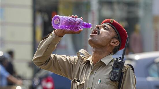 A policeman drinks water on a hot summer day, in Lucknow, on May 22. (PTI)