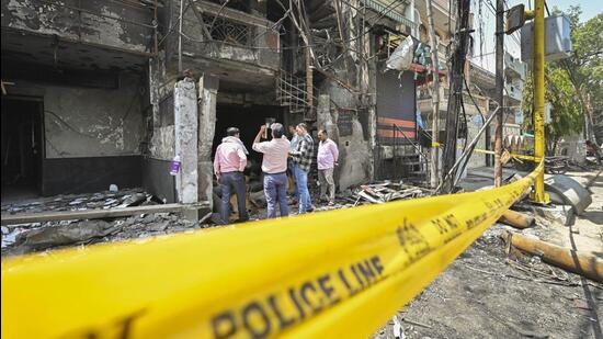 Civic officials inspect the site of the hospital, which went up in flames on Saturday night. (Raj K Raj/HT Photo)