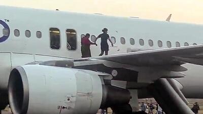 A crew member helps an elderly passenger evacuate the aircraft through the emergency door on Tuesday. (ANI) A crew member helps an elderly passenger evacuate the aircraft through the emergency door on Tuesday. (ANI)