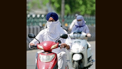 Commuters cover their face to protect themselves from the scorching sun in Bathinda on Wednesday.With a forecast of sparse rainfall over some parts of the state during the next 48 hours, Punjab will likely get some relief from the scorching heat. (Sanjeev Kumar /HT)