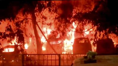 Vehicles engulfed in flames at the parking lot on Tuesday night. (PTI) Vehicles engulfed in flames at the parking lot on Tuesday night. (PTI)