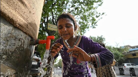 A woman washes her face in an attempt to cool herself from scorching sun. (Sanchit Khanna/HT Photo)