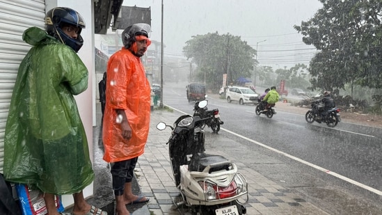 Two men who were riding a two-wheeler take shelter outside a closed shop during a heavy rain in Kochi, southern Kerala state, India. The Indian Meteorological Department has forecast an early onset of monsoon with an above-average rainfall. Kerala: Tourist centers closed, night travel ban imposed as heavy rains trigger landslides (AP Photo/ R S Iyer)