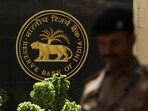 A police officer walks past the Reserve Bank of India (RBI) logo inside its headquarters in Mumbai, India.