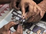 An election official puts indelible ink on the finger of an elderly voter. (AP Photo)