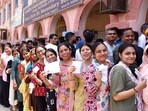 Voters display identity cards while standing in queue to cast their votes at a polling booth for the sixth phase of Lok Sabha elections on May 25.