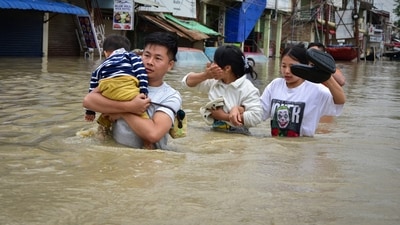 A man carries his child through a flooded area to a safer place after heavy rains caused by Cyclone Remal in Imphal, Manipur, India, May 29, 2024. REUTERS/Stringer (REUTERS)