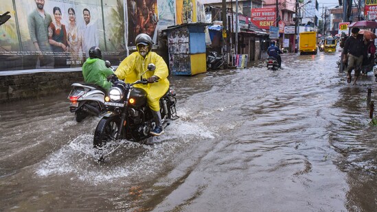 Commuters traverse a waterlogged road in Kochi on Wednesday, amidst rainfall. As floodwaters recede in Kochi and its environs, locals initiate the process of cleaning their residences.(PTI)