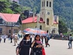 Residents using an umbrella to shield themselves from the heat on The Ridge, Shimla. Residents using an umbrella to shield themselves from the heat on The Ridge, Shimla.
