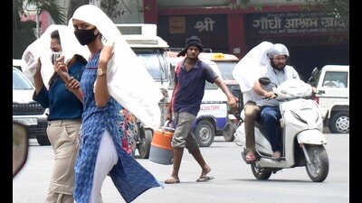 Commuters cover their heads on yet another extremely hot day in Prayagraj on Friday. (HT Photo) Commuters cover their heads on yet another extremely hot day in Prayagraj on Friday. (HT Photo)