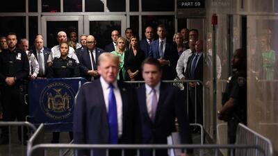 Members of former US President Donald Trump's entourage watch as he speaks alongside his attorney. (Getty Images via AFP) Members of former US President Donald Trump's entourage watch as he speaks alongside his attorney. (Getty Images via AFP)
