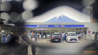 Mt. Fuji is seen through a hole on a black screen installed across from a convenience store in Fujikawaguchiko town, Yamanashi prefecture, central Japan. The town that erected the huge black screen last week in an attempt to stop tourists from snapping photos of Mount Fuji and overcrowding the area has discovered holes in the screen and is working to repair them, officials said Tuesday. (Photo by Kyodo News via AP) Mt. Fuji is seen through a hole on a black screen installed across from a convenience store in Fujikawaguchiko town, Yamanashi prefecture, central Japan. The town that erected the huge black screen last week in an attempt to stop tourists from snapping photos of Mount Fuji and overcrowding the area has discovered holes in the screen and is working to repair them, officials said Tuesday. (Photo by Kyodo News via AP)