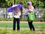 Women wearing scarves walk in a garden on a hot summer day in New Delhi on May 30, 2024, Women wearing scarves walk in a garden on a hot summer day in New Delhi on May 30, 2024,